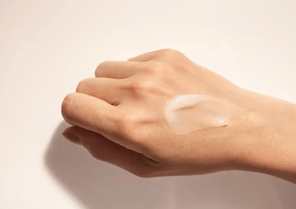 A hand with a small amount of ceramide-based skincare product applied, showcasing its smooth, translucent texture.