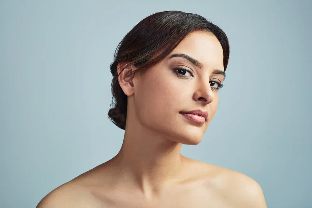 A woman with glowing, smooth skin, looking confidently at the camera, highlighting healthy collagen levels and youthful appearance.